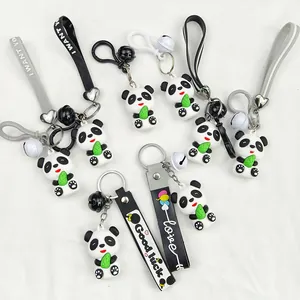 Close-up of multiple cute cartoon panda keychains with bells and colorful lanyards.