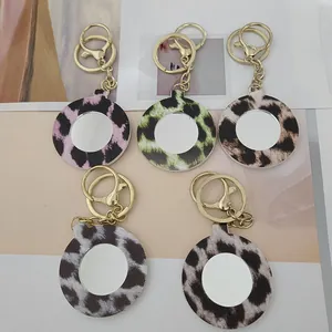 Vue détaillée de cinq porte-clés miroir de maquillage portables en cuir à motif léopard varié.