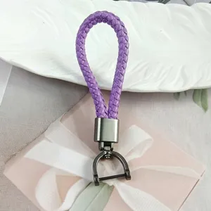 Detail shot of purple braided leather keychain with gunmetal horseshoe clasp on gift box