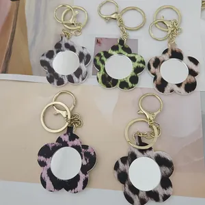 Vue détaillée de porte-clés en cuir léopard en forme de fleur avec miroirs de poche.