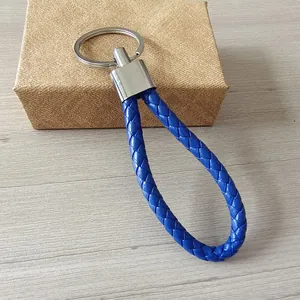 Vista detallada de un llavero de cuero PU trenzado azul con un anillo de metal plateado
