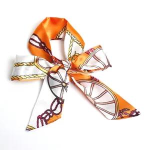 Macro view of an orange and white equestrian pattern silk ribbon scarf tied into a neat bow