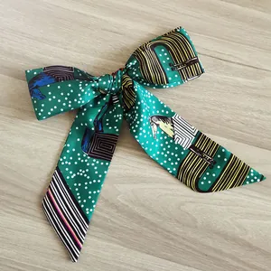 Diadema con lazo verde de lunares con motivo de caballos y rayas sobre madera.
