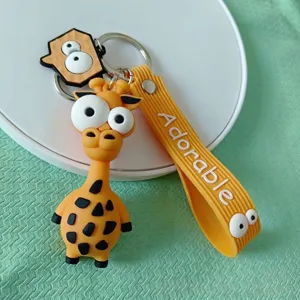 Detalle de un bonito llavero de jirafa con ojos grandes y correa con texto Adorable