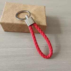 Vista detallada de un llavero de cuero trenzado rojo con un anillo de metal plateado