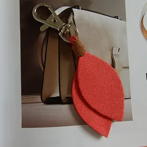 Detailed view of a red velvet leaf keychain charm with silver metal clasp