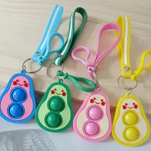 Set of colorful avocado-shaped silicone pop-it fidget toy keychains on wooden surface