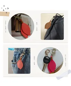 Detail view of leaf shaped suede keychain charms on bags and denim jeans