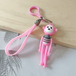 Close-up of a pink long-legged cartoon monkey keychain featuring a grey striped shirt detail