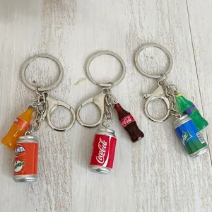 Detail of miniature soda bottle and can keychains including Coca-Cola and Fanta designs