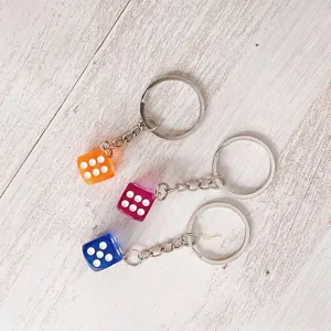 Set of three colorful acrylic dice keychains in orange, purple, and blue colors.