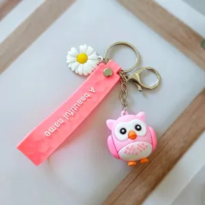 Nahaufnahme eines rosa Eulen-Schlüsselanhängers mit Gänseblümchen und Reliefband