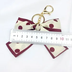 Porte-clés nœud en tissu à pois vintage mesuré avec une règle pour référence de taille