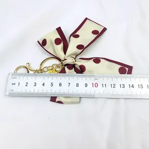 Vue détaillée du porte-clés ruban en soie à pois vintage avec règle de mesure de taille