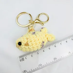Detail view of a handmade crocheted yellow clownfish keychain with measuring ruler