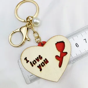 Détail d'un porte-clés en bois en forme de cœur avec gravure I love you et tulipe