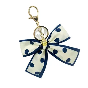 Porte-clés élégant en tissu à pois avec charm porte-bonheur doré pour sacs
