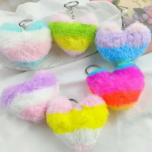 Close-up of five rainbow gradient heart-shaped plush keychains on a white tray.