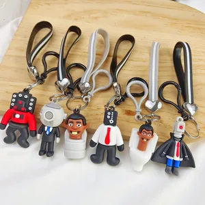 Detailed shot of six Skibidi Toilet character keychains displayed on a wooden surface.