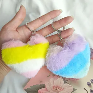 Gros plan de porte-clés en peluche en forme de cœur avec un dégradé de couleur arc-en-ciel.