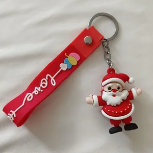 Détail d'un porte-clés Père Noël en silicone 3D avec une lanière rouge gravée Love