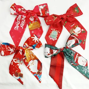 Detailed view of four festive Christmas silk scarf bows with Santa and tree patterns