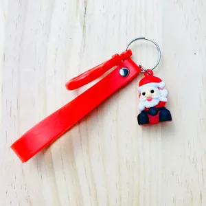 Detailed macro view showing a cute Santa Claus figure and red silicone strap on this holiday keychain