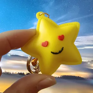 Grazioso portachiavi a stella gialla con occhi a cuore e sorriso, tenuto in mano