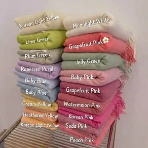 Collection of soft knitted winter scarves in multiple pastel colors with tassel details
