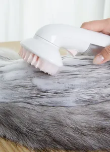 Gros plan d'une brosse de bain pour animaux créant de la mousse avec des picots roses