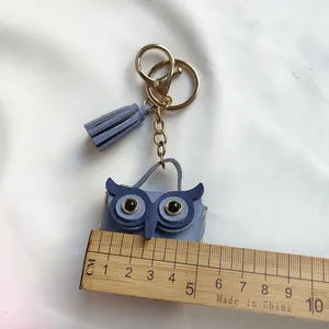 Vue détaillée d'un porte-clés hibou mignon en cuir violet avec gland et règle de mesure