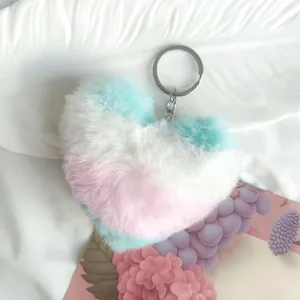 Porte-clés en peluche douce en forme de cœur avec dégradé pastel posé sur fond blanc