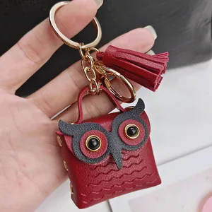 Vue détaillée d'un porte-clés hibou en cuir rouge avec gland doré et anneau.