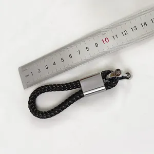 Braided PU leather keychain with silver horseshoe buckle and ruler for size scale.