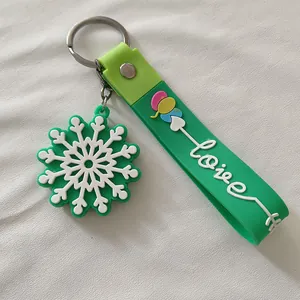 Détail d'un porte-clés de Noël en silicone vert avec flocon de neige et mot Love