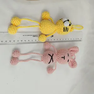 Llaveros de animales de ganchillo hechos a mano en amarillo y rosa mostrados con una regla de medida.