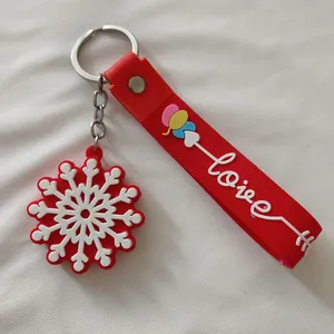 Détail du porte-clés de Noël en silicone rouge avec flocon de neige et sangle 'love'