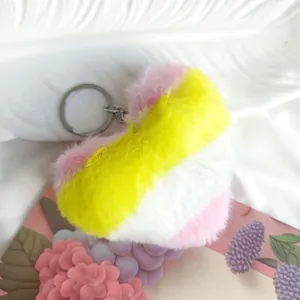 Détail d'un porte-clés en peluche en forme de cœur avec un dégradé arc-en-ciel.