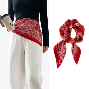 Styling detail of red paisley silk bandana used as a decorative waist scarf belt