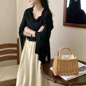 Elegante scialle parasole nero con dettaglio bottone indossato su abito color crema