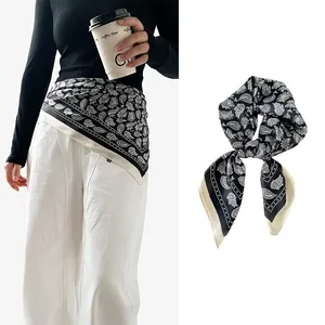 Detailed view of a dark blue paisley silk scarf used as a waist belt and tied knot