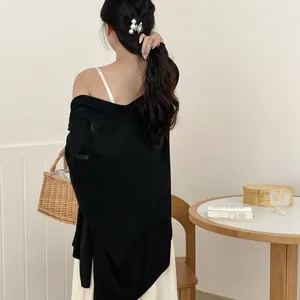 Donna elegante con scialle nero leggero per protezione solare vista dal retro
