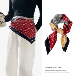 Detail of a paisley print silk scarf worn as a waist belt and neck accessory for styling.