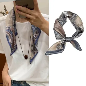 Detail view of navy blue paisley silk scarf elegantly styled as a chic necktie accessory