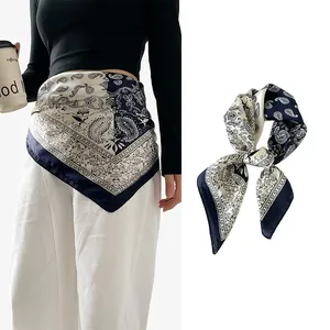 Detail view of navy paisley silk scarf styled as a fashionable waist belt
