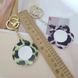 Vue détaillée de porte-clés miroir en cuir léopard avec une règle pour la taille