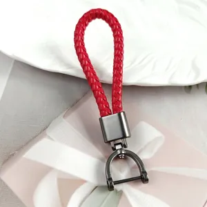 Macro view of a red braided leather keychain with a metallic gunmetal horseshoe buckle