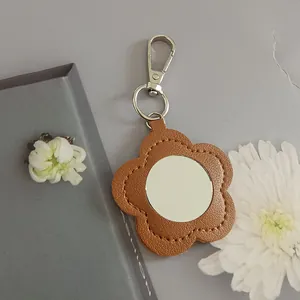 Elegant flower-shaped PU leather keychain featuring a built-in portable circular makeup mirror