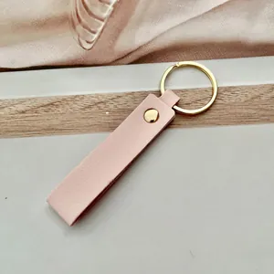 Llavero minimalista de cuero PU rosa macaron con un elegante anillo de metal dorado.