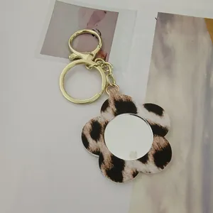 Détail d'un porte-clés fleur à motif léopard avec un petit miroir de poche portable
